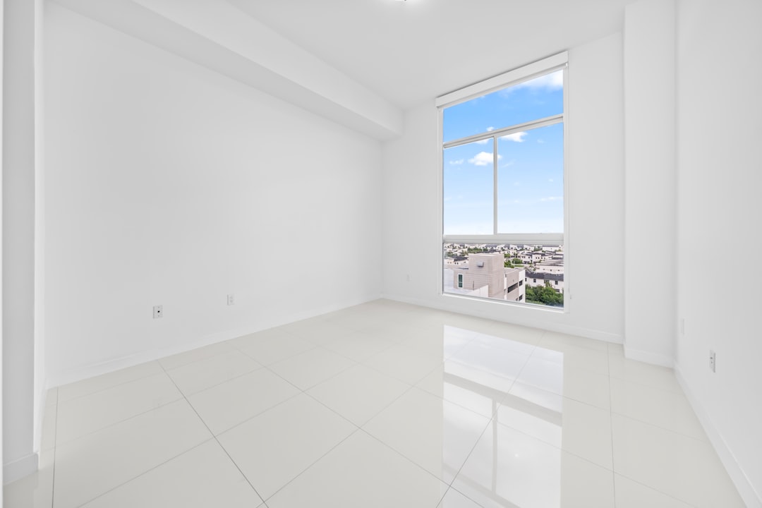 Empty white room with a large window overlooking city